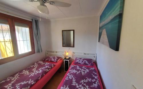 ein kleines Schlafzimmer mit 2 Betten und einem Spiegel in der Unterkunft Haus Mundo La Marina Urbanisation in San Fulgencio