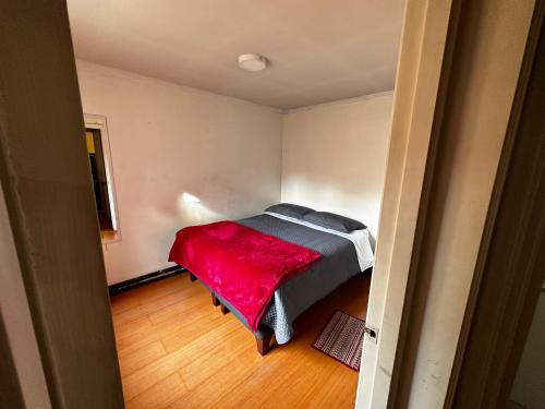 a bedroom with a bed with a red blanket on it at Enjoy Budget in Santiago