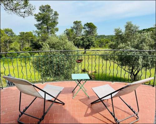 une paire de chaises et une table sur un balcon dans l'établissement Villa 13 personnes - 1 hectare de parc naturel - piscine, à Saint-Clément-de-Rivière