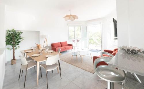 un salon blanc avec une table et des chaises dans l'établissement Villa 13 personnes - 1 hectare de parc naturel - piscine, à Saint-Clément-de-Rivière