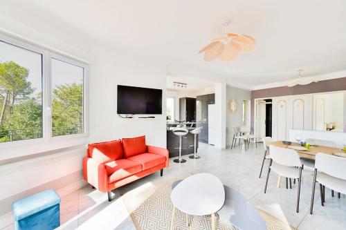 un salon avec un canapé rouge et une table dans l'établissement Villa 13 personnes - 1 hectare de parc naturel - piscine, à Saint-Clément-de-Rivière