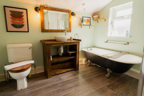 La salle de bains est pourvue d'une baignoire, de toilettes et d'un lavabo. dans l'établissement Well located 3 bedroom home in central Chester with Parking, à Chester