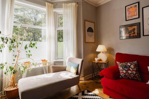a living room with a red couch and a window at Well located 3 bedroom home in central Chester with Parking in Chester