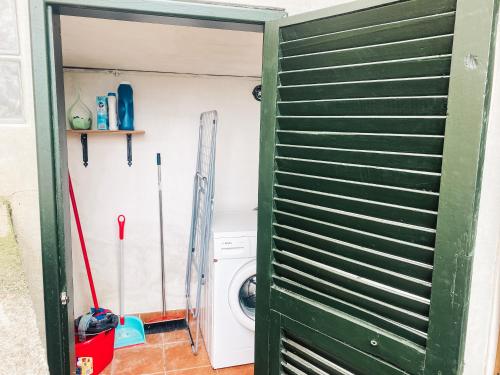 a laundry room with a washing machine and a green door at Il Nido sullo Scoglio in Bonassola