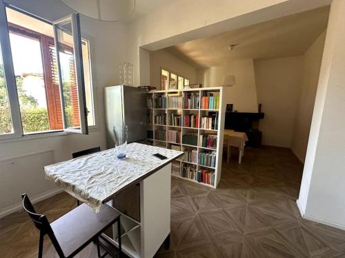 uma cozinha com uma mesa e uma estante de livros em Casa Vacanza Mondello em Palermo