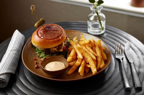 a plate with a sandwich and french fries on a table at Inn at Bellefield Residence Inn by Marriott in Hyde Park