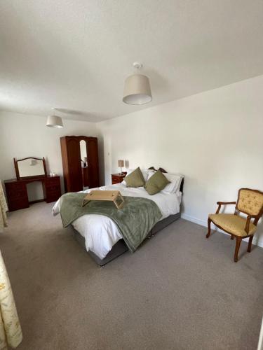 a bedroom with a large bed and a chair at Teasy's cottage in Armagh