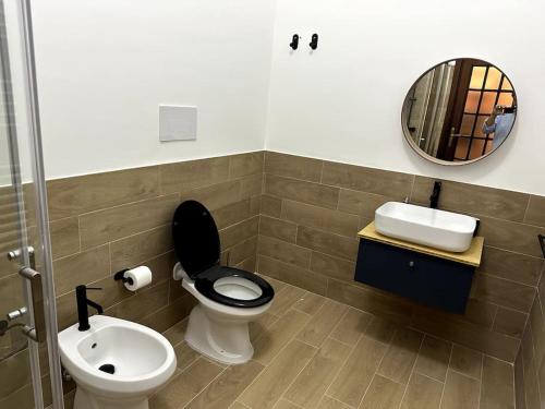 uma casa de banho com um WC, um lavatório e um espelho. em Casa Vacanza Mondello em Palermo