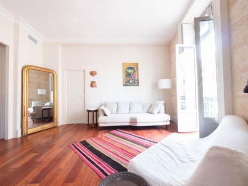 - un salon avec un canapé blanc et un miroir dans l'établissement L'opéra - Climatisation et vue imprenable, à Montpellier