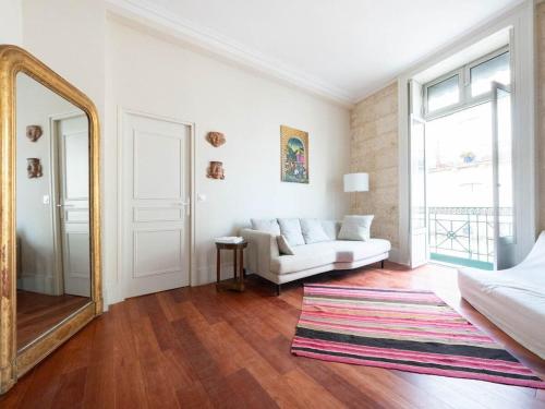 un salon avec un canapé et un miroir dans l'établissement L'opéra - Climatisation et vue imprenable, à Montpellier