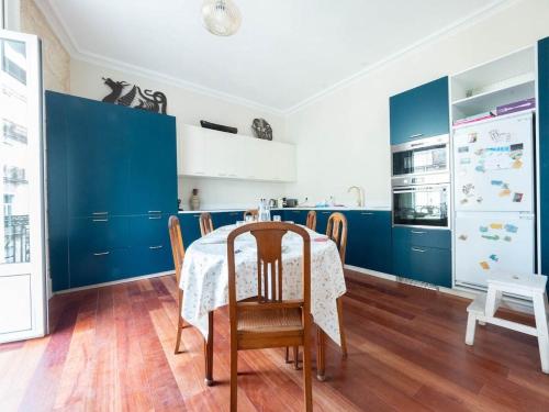 une cuisine avec des placards bleus et une table avec des chaises dans l'établissement L'opéra - Climatisation et vue imprenable, à Montpellier