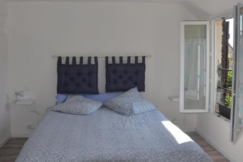 - une chambre avec un lit bleu et 2 oreillers dans l'établissement Les Agapanthes, à Vernon