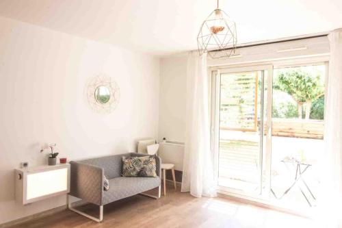 un salon avec une chaise et une fenêtre dans l'établissement Le Tropisme - Terrasse en centre ville, à Montpellier