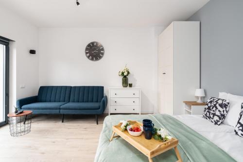 uma sala de estar com uma cama e um sofá azul em Krośnieńska Studios on Ground Level by Renters em Poznań