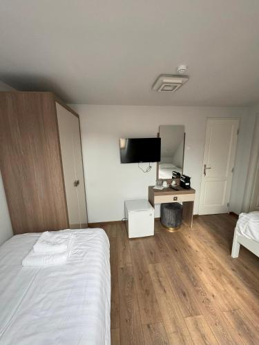 a bedroom with a bed and a desk with a television at Pensiunea Korona in Miercurea-Ciuc
