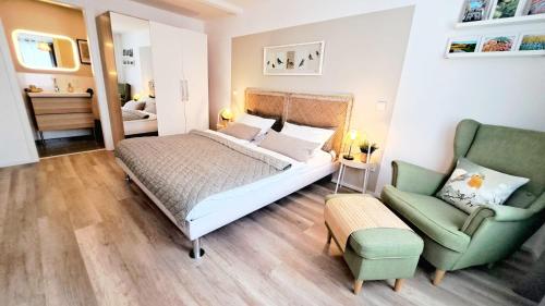 um quarto com uma cama e uma cadeira verde em Ferienwohnung Rauch em Kirrweiler