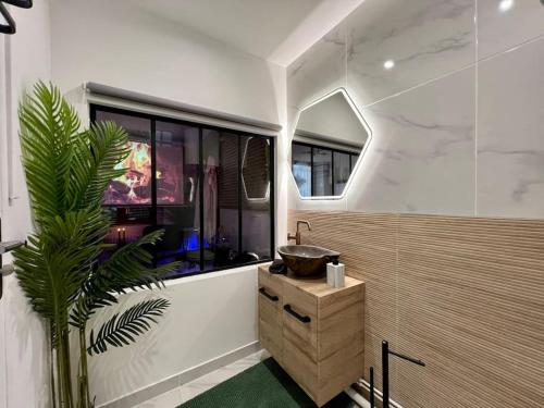 une salle de bain avec un lavabo et une fenêtre dans l'établissement Black Love-room - Balnéo - Cinéma, à Souppes-sur-Loing