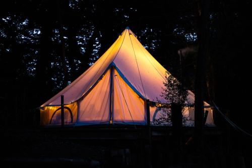 a lit up tent in the dark at Cuddfan Bach (The Little Hideaway) at Camp Plas in Welshpool