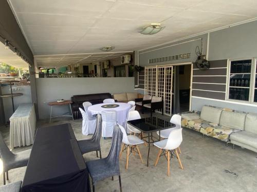 ein Wohnzimmer mit einem Tisch, Stühlen und einem Sofa in der Unterkunft MARIDA HOMESTAY MusIim Only in Seremban