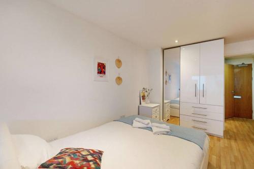 a white bedroom with a bed and a mirror at Stunning studio apt- 5 min walk to Borough station in London