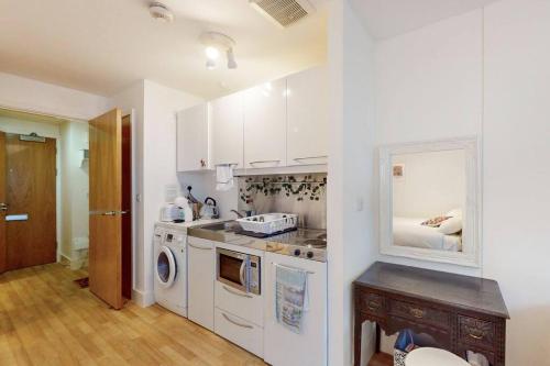 a kitchen with a sink and a washer and dryer at Stunning studio apt- 5 min walk to Borough station in London