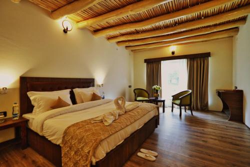 La Shayok Resort في نوبرا: غرفة نوم بسرير كبير في غرفة