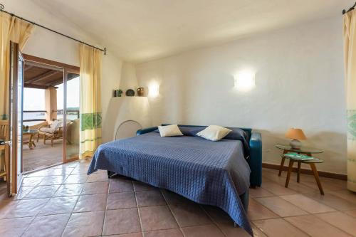 a bedroom with a bed with a blue bedspread at Grande Villa Golfo degli Angeli in Torre delle Stelle