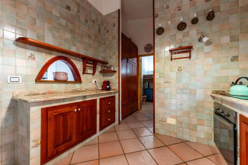 uma cozinha com armários de madeira e uma parede de azulejos em Grande Villa Golfo degli Angeli em Torre delle Stelle