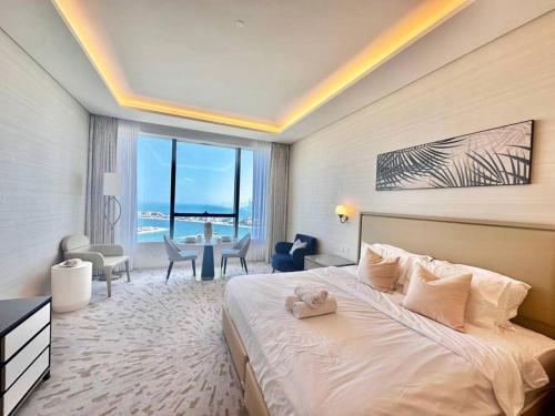 Luxury Studio in High Floor Full Sea View in The Palm Tower Plam Jumeirah في دبي: غرفة نوم مع سرير مع دمية دب عليها