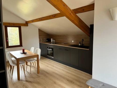 a kitchen with a table and chairs in a room at Le studio de la cascade in Tendon