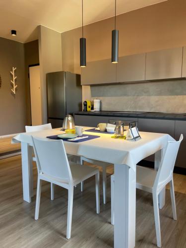 kuchnia z białym stołem i białymi krzesłami w obiekcie Casa i Portici w Arezzo