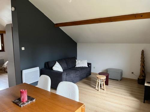 a living room with a couch and a table at Le studio de la cascade in Tendon