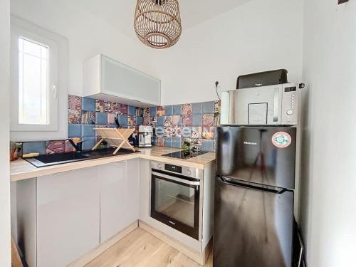 une cuisine avec un réfrigérateur en acier inoxydable et un micro-ondes dans l'établissement APPA3255-T2 à 400m de la plage, à Argelès-sur-Mer