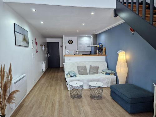 un salon avec un canapé et un escalier dans l'établissement Magnifique logement d'architecte 3* sur Palavas, à Palavas-les-Flots