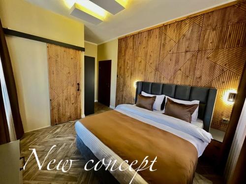 Edremit的住宿－Miro Mara Boutique Hotel & Lounge Bar，一间卧室设有一张带木墙的大床