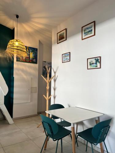 a dining room with a white table and chairs at Appartement centre-ville de St Leu in Saint-Leu