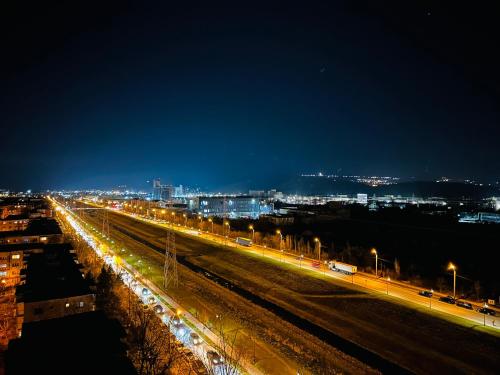 une ville éclairée la nuit avec des lumières de rue dans l'établissement Panoramic Sunrise near IULIUS MALL by cityZen Suites, à Iaşi