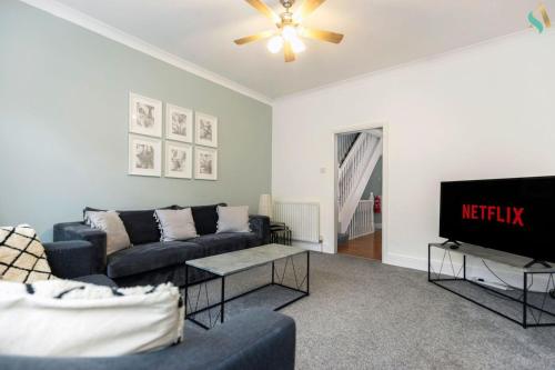 Una sala de estar con un sofá y un televisor. en Pine House, en Stockton-on-Tees