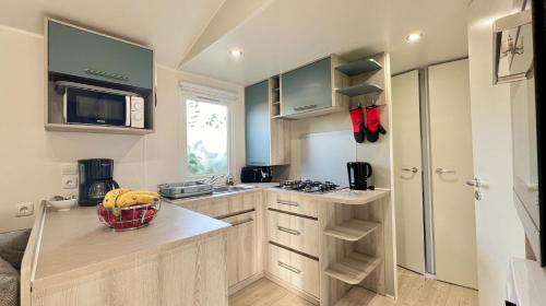 een kleine keuken met een wastafel en een magnetron bij Mobile-Home Le Mimosa Camping SIBLU**** in Fréjus
