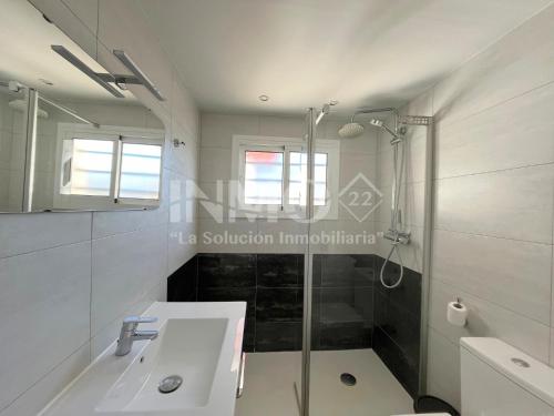 een witte badkamer met een douche en een wastafel bij Estudio reformado en zona Regueral 123A - INMO22 in Cambrils