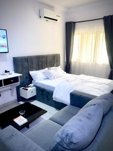 a bedroom with a large bed and a couch at Executive suite escape in Lekki