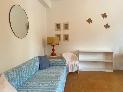 een woonkamer met een blauwe bank en een spiegel bij Bilocale 4 posti terrazza posto auto in Numana