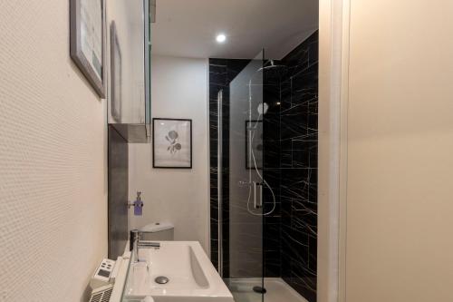 a bathroom with a sink and a shower at Cœur de Fontainebleau: Confort, Calme & Haut débit in Fontainebleau