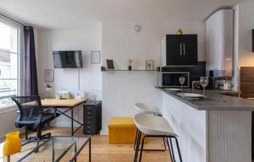 a kitchen with a counter and chairs and a table at Cœur de Fontainebleau: Confort, Calme & Haut débit in Fontainebleau