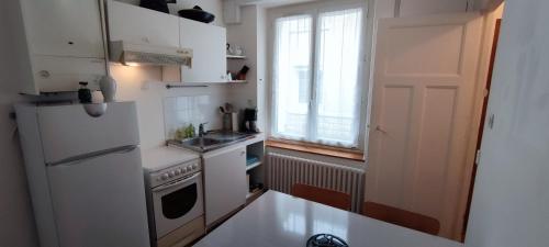 uma cozinha com um frigorífico branco e um lavatório em Agréable maison de ville proche centre ville em Nantes