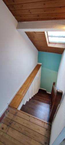 - un escalier dans une maison dotée de parquet et d'une fenêtre dans l'établissement Agréable maison de ville proche centre ville, à Nantes