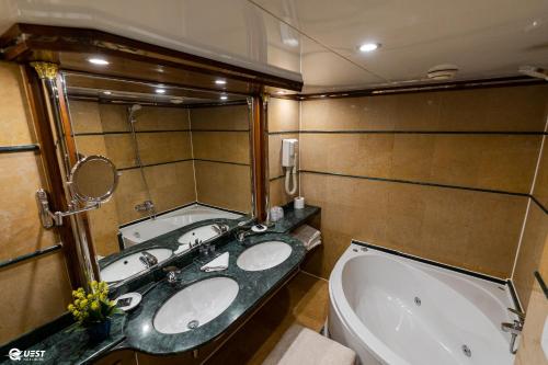 La salle de bains est pourvue de 2 lavabos et d'une baignoire. dans l'établissement M/S Nile Quest Cruise - 4 or 7 Nights From Luxor each Monday and 3 or 7 Nights From Aswan each Friday, à Louxor