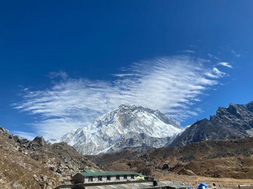 une montagne enneigée avec un bâtiment devant elle dans l'établissement Sherpa Lodge, à Lobujya