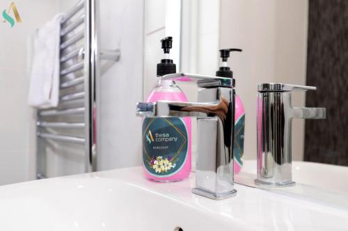 a bathroom sink with a bottle of soap and a soap dispenser at Wharf House TSAC in Stockton-on-Tees