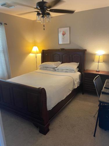 a bedroom with a large bed with a ceiling fan at House 8122 in Humble